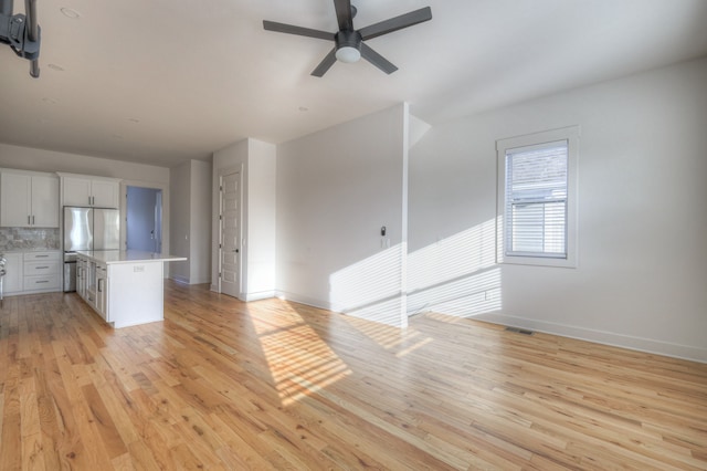 unfurnished living room featuring ceiling fan and light hardwood / wood-style floors