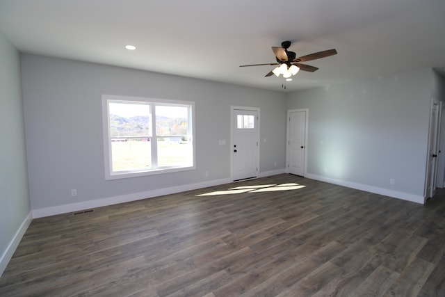 spare room featuring dark wood-type flooring and ceiling fan