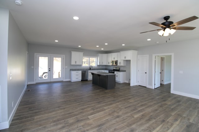 kitchen with white cabinets, dark hardwood / wood-style floors, appliances with stainless steel finishes, and a kitchen island