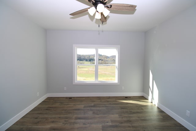 spare room with ceiling fan and dark hardwood / wood-style floors