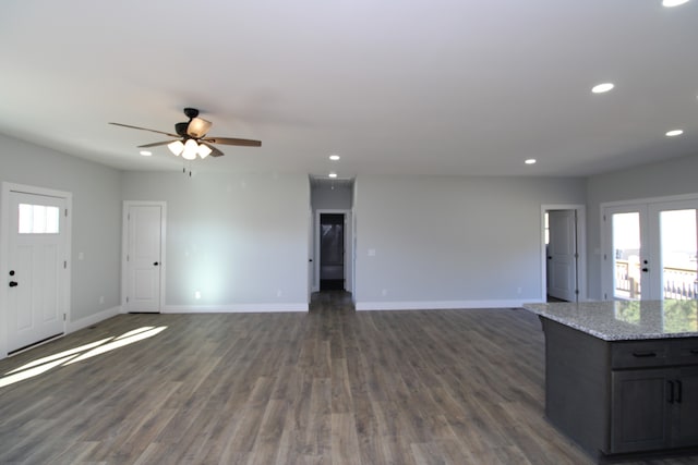 unfurnished living room featuring dark wood-type flooring, ceiling fan, and french doors