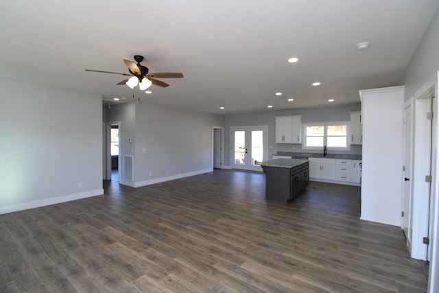 kitchen with french doors, dark hardwood / wood-style flooring, white cabinets, ceiling fan, and a kitchen island