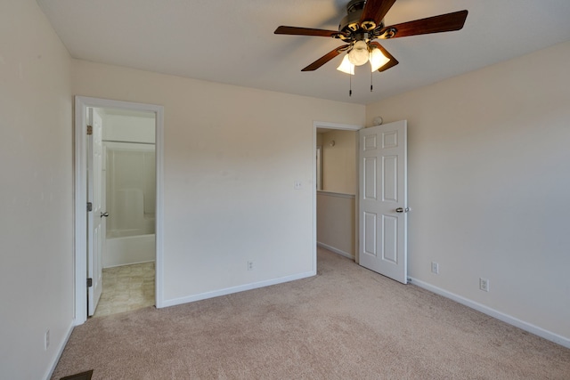 unfurnished bedroom featuring ceiling fan, ensuite bath, and light colored carpet