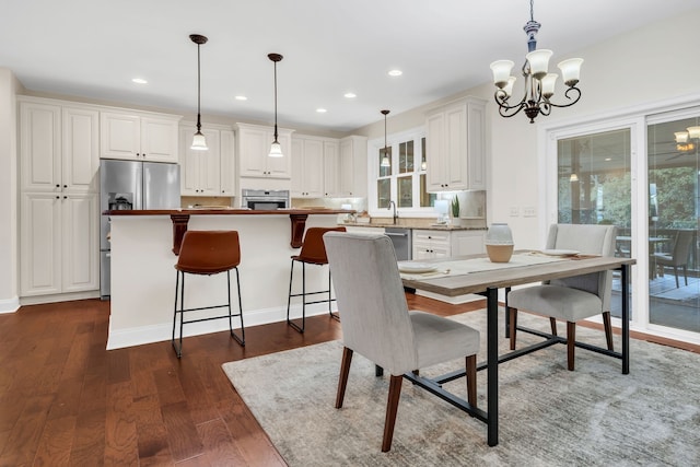 dining room featuring a chandelier, a healthy amount of sunlight, and dark hardwood / wood-style flooring