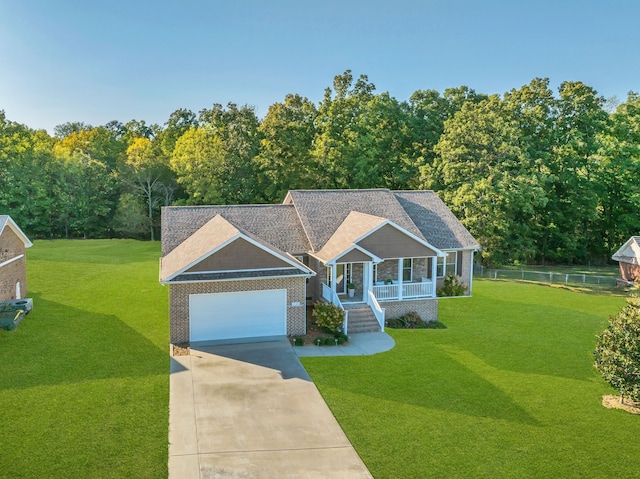 view of front of house with covered porch, a garage, and a front yard