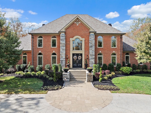 colonial-style house featuring a front lawn and french doors