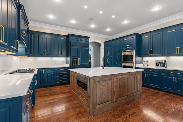 kitchen with built in appliances, dark wood-type flooring, and an island with sink