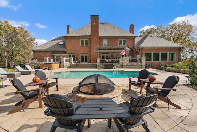 view of swimming pool with a fire pit and a patio area