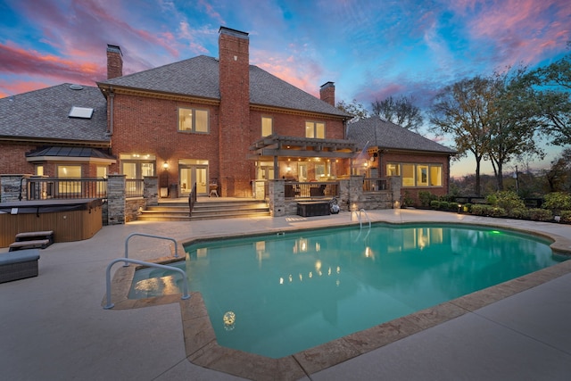 pool at dusk featuring a hot tub, a pergola, and a patio area