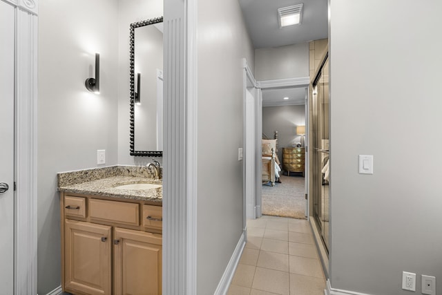 bathroom with walk in shower, tile patterned flooring, and vanity