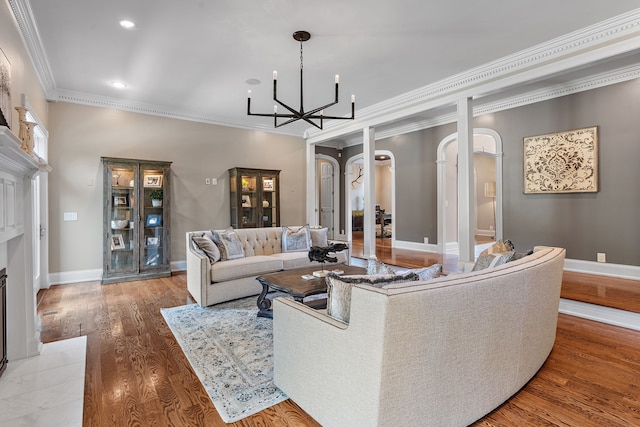 living room featuring ornamental molding, wood-type flooring, and a chandelier