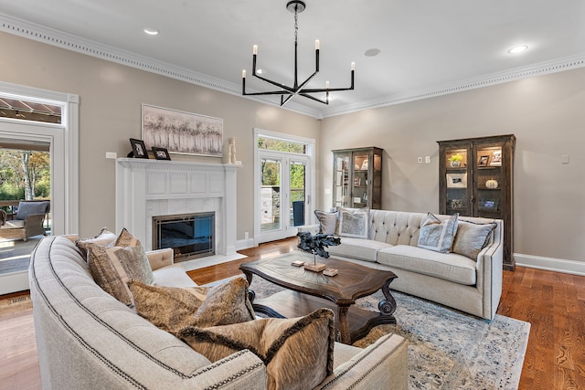 living room featuring a fireplace, wood-type flooring, a healthy amount of sunlight, and crown molding