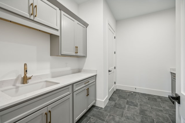 laundry area with baseboards and a sink