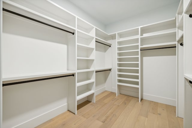 walk in closet with light hardwood / wood-style floors