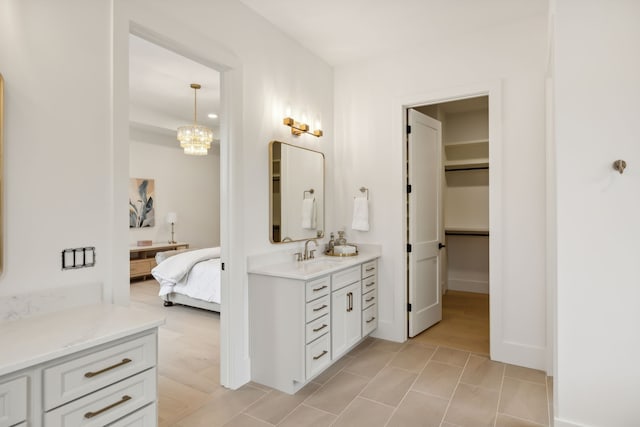 bathroom featuring a spacious closet, vanity, ensuite bathroom, and an inviting chandelier