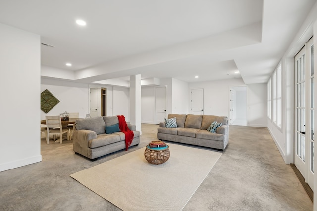 living room featuring visible vents, concrete floors, baseboards, recessed lighting, and a raised ceiling