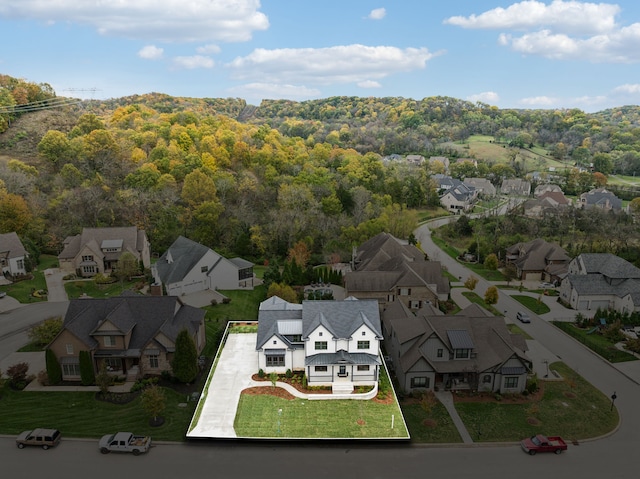 birds eye view of property with a forest view and a residential view