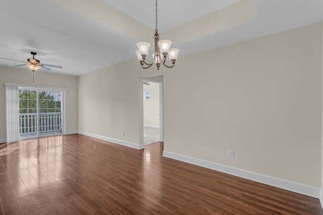 spare room featuring ceiling fan with notable chandelier and dark wood-type flooring