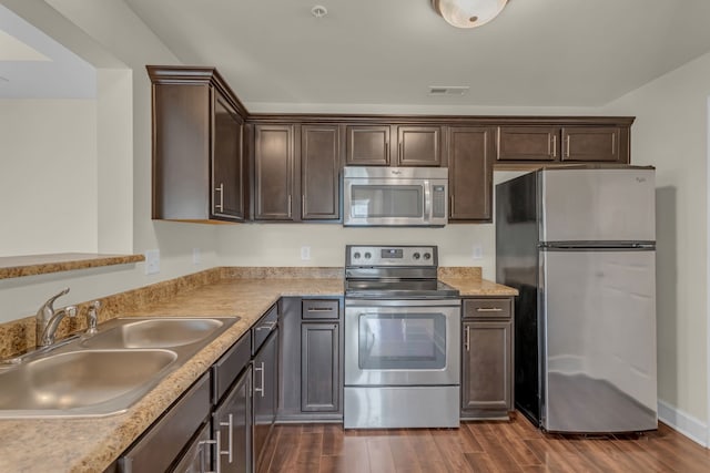 kitchen featuring dark brown cabinets, dark hardwood / wood-style floors, sink, and appliances with stainless steel finishes