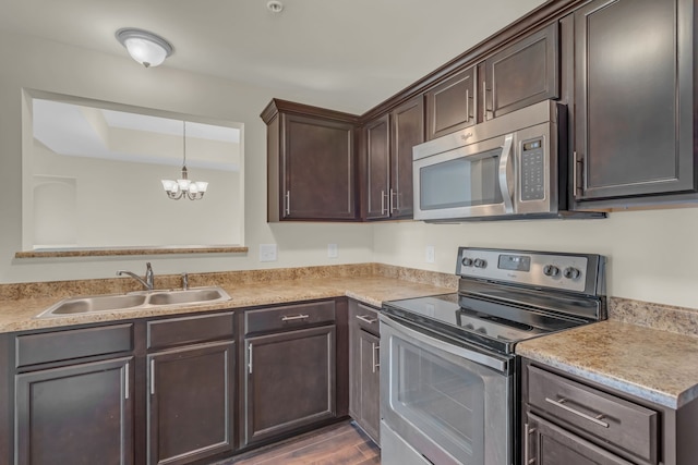 kitchen featuring an inviting chandelier, dark brown cabinetry, hardwood / wood-style flooring, sink, and appliances with stainless steel finishes