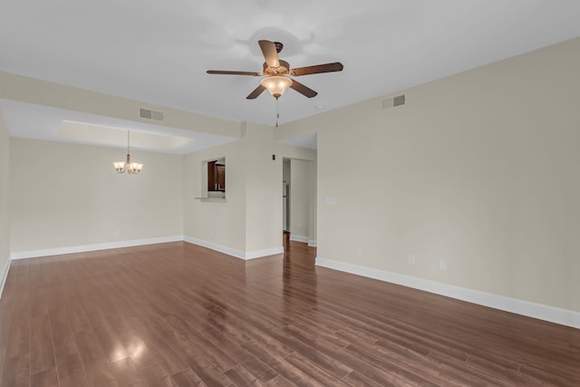 empty room with ceiling fan with notable chandelier and dark wood-type flooring