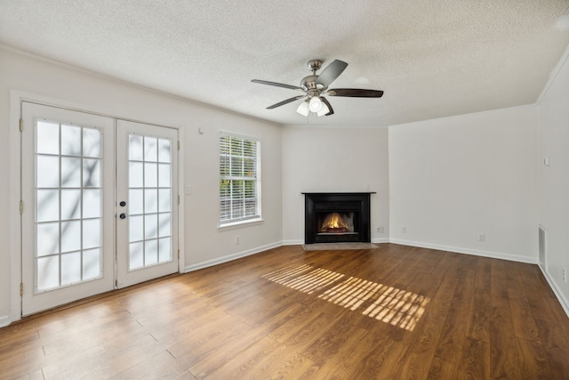 unfurnished living room featuring french doors, hardwood / wood-style flooring, ceiling fan, and a textured ceiling