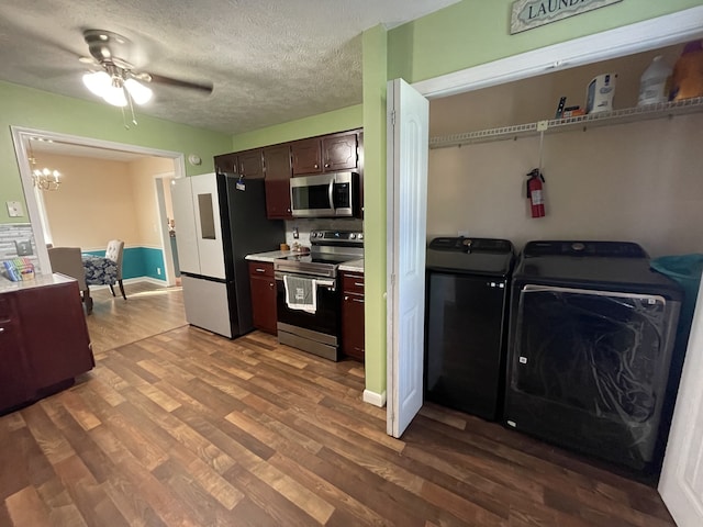 kitchen with stainless steel appliances, separate washer and dryer, ceiling fan with notable chandelier, dark brown cabinets, and wood-type flooring