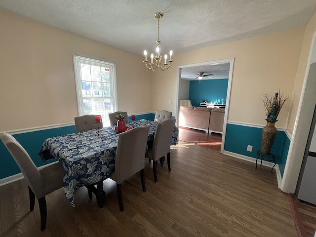 dining space with dark hardwood / wood-style floors, a textured ceiling, and ceiling fan with notable chandelier