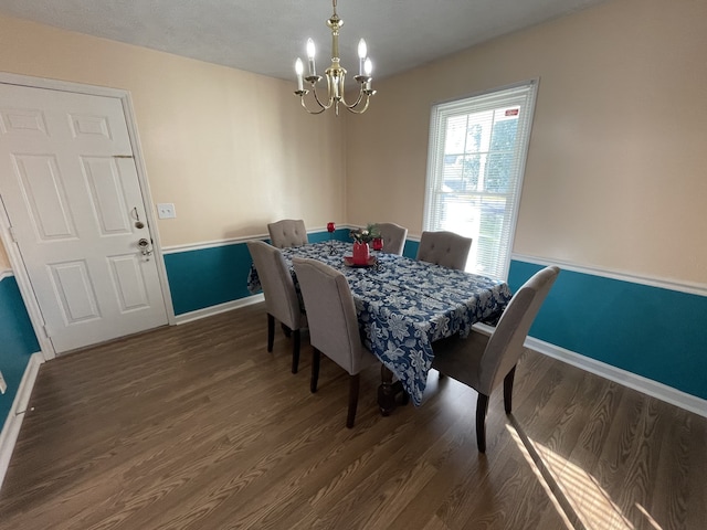 dining space featuring dark wood-type flooring and a chandelier