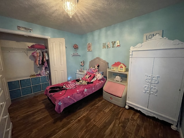 bedroom featuring a closet, a textured ceiling, and dark hardwood / wood-style floors