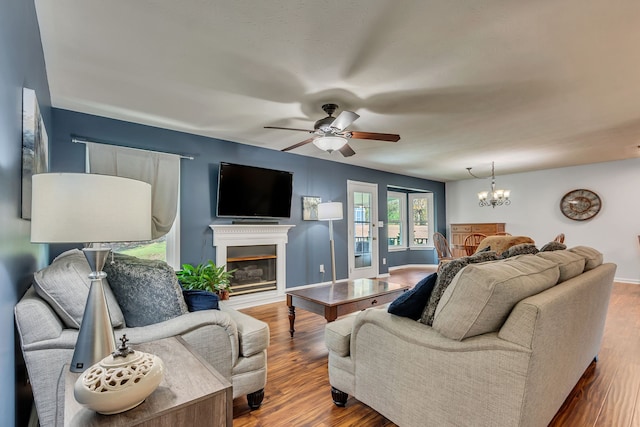 living room with hardwood / wood-style flooring and ceiling fan with notable chandelier