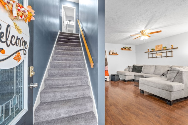 stairway featuring a textured ceiling, hardwood / wood-style flooring, and ceiling fan