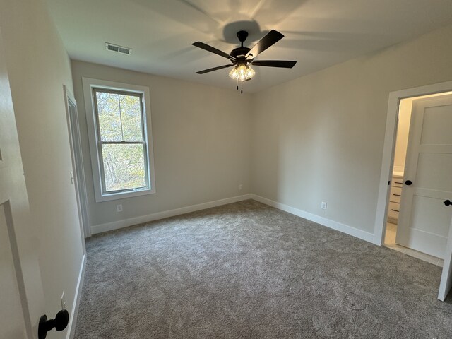 empty room featuring ceiling fan and light colored carpet