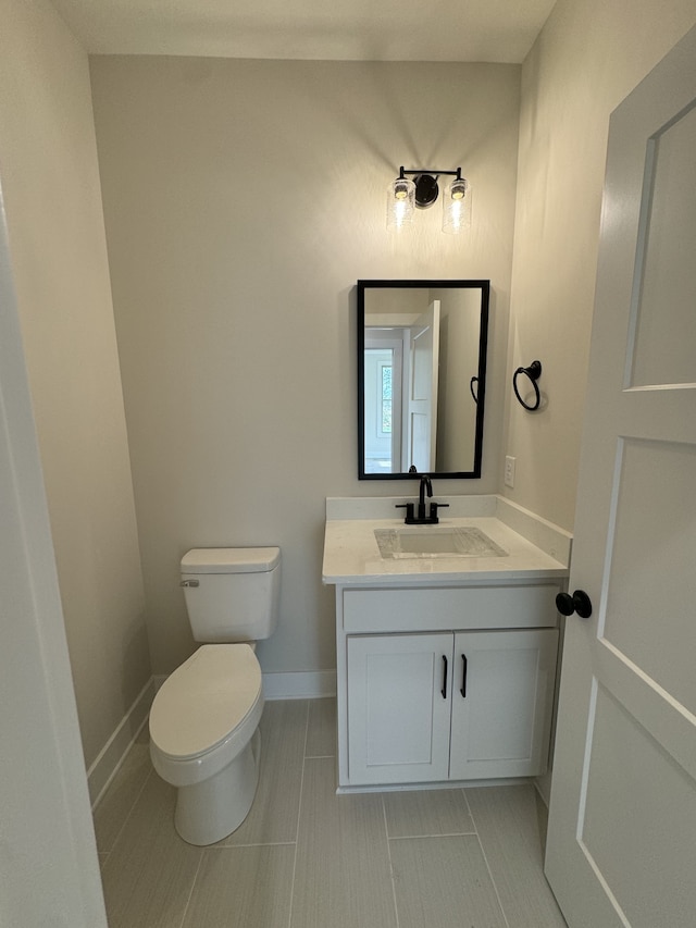 bathroom featuring tile patterned floors, vanity, and toilet