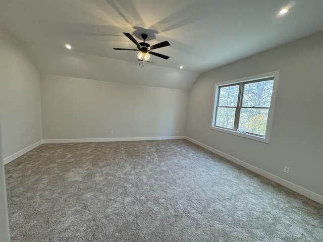 carpeted empty room featuring ceiling fan and lofted ceiling