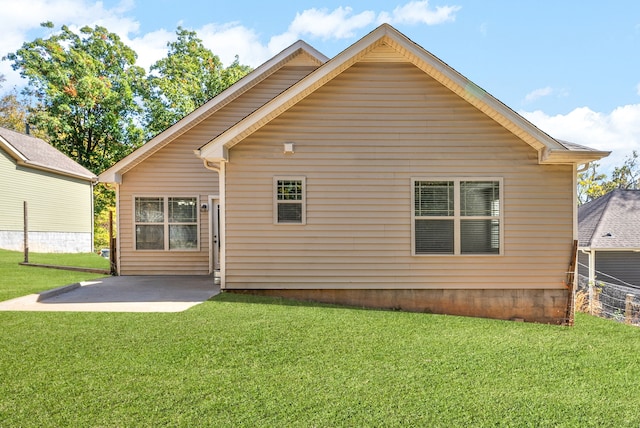 back of house featuring a lawn and a patio area