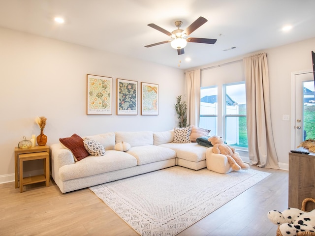 living room featuring light wood-type flooring and ceiling fan