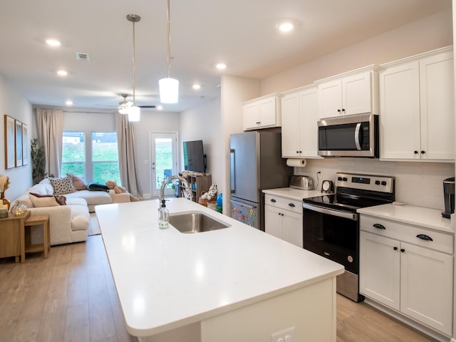 kitchen featuring white cabinetry, sink, a center island with sink, and stainless steel appliances