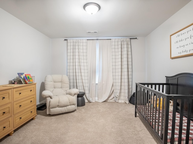 carpeted bedroom featuring a nursery area