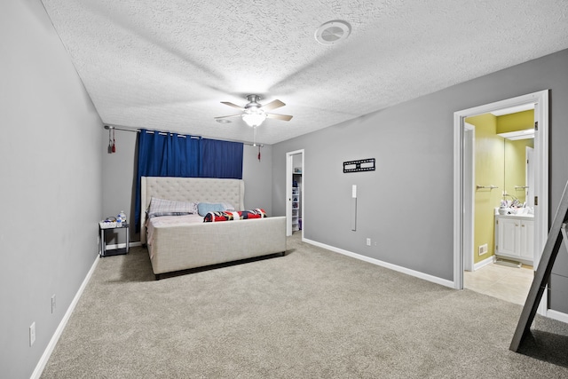 carpeted bedroom featuring ensuite bathroom, ceiling fan, and a textured ceiling