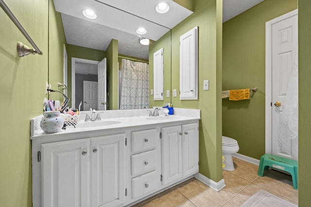 bathroom with tile patterned flooring, vanity, and toilet