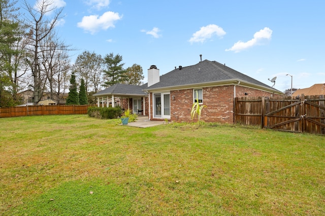 rear view of property with a patio and a lawn