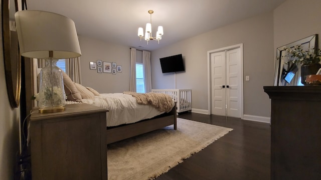 bedroom with dark hardwood / wood-style floors and an inviting chandelier