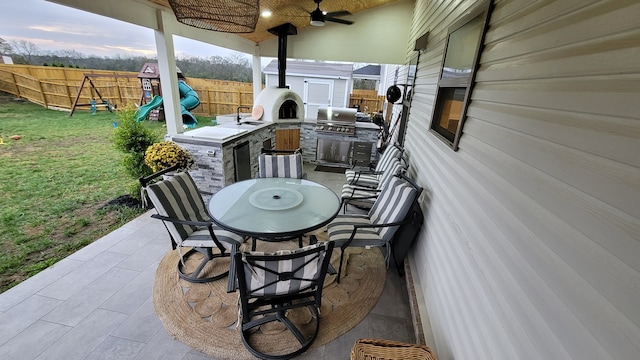 view of patio with a playground, area for grilling, and ceiling fan