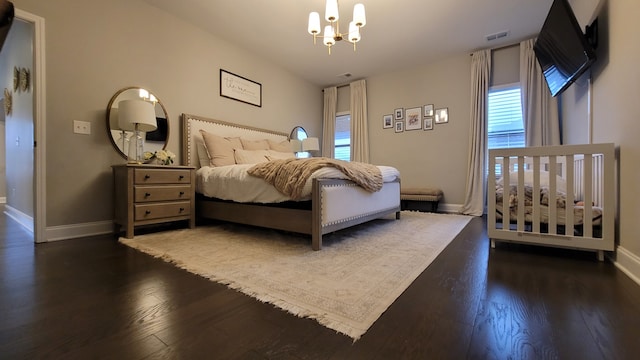 bedroom featuring dark wood-type flooring and an inviting chandelier