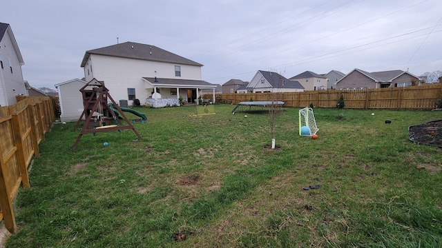 view of yard with a playground and a trampoline