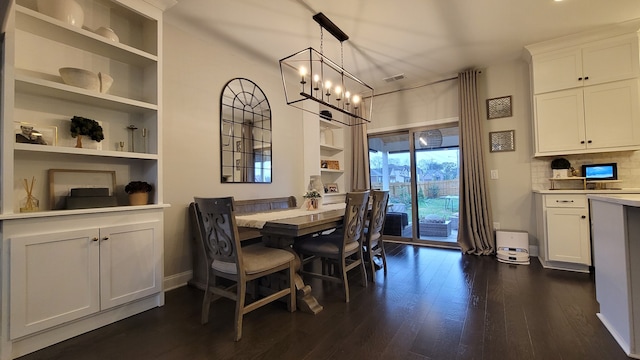 dining space with dark hardwood / wood-style flooring and a chandelier