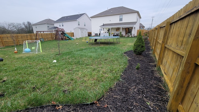 view of yard with a playground and a trampoline