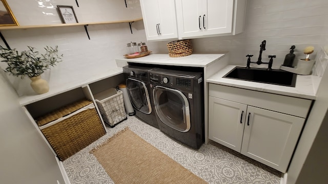 washroom featuring cabinets, sink, and washing machine and clothes dryer