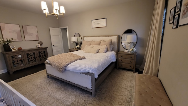 bedroom with a notable chandelier and dark hardwood / wood-style floors